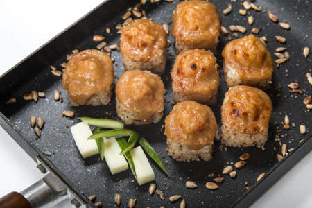 Japanese sushi rolls on a black frying pan. close viewの写真素材