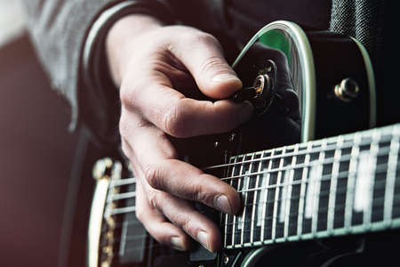 Close up shot of Hands of man playing electric guitar.の写真素材