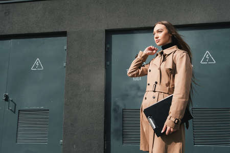Self-confidence young business woman with file in a hand. outdoor. cityscapeの写真素材