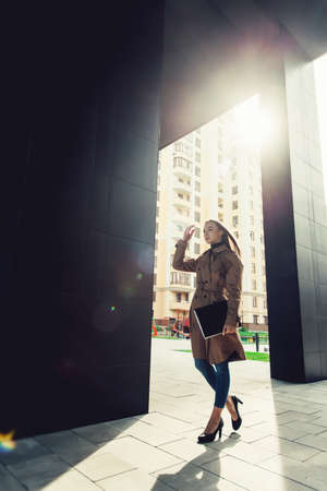 Self-confidence young business woman with file in a hand. outdoor. cityscapeの写真素材