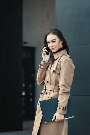 Self-confidence young business woman with file in a hand. outdoor. cityscapeの写真素材