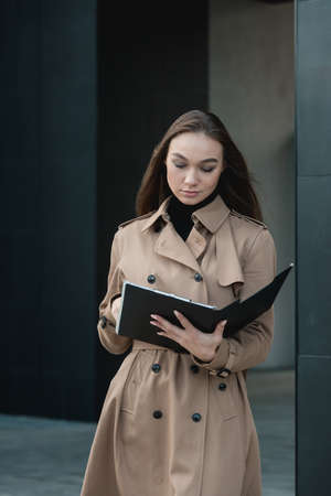 Self-confidence young business woman with file in a hand. outdoor. cityscapeの写真素材