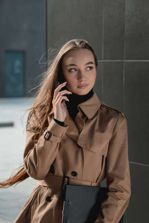Self-confidence young business woman with file in a hand. outdoor. cityscapeの写真素材