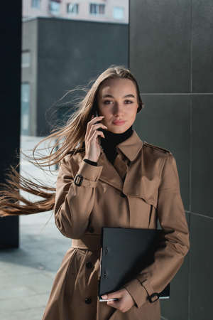 Self-confidence young business woman with file in a hand. outdoor. cityscapeの写真素材