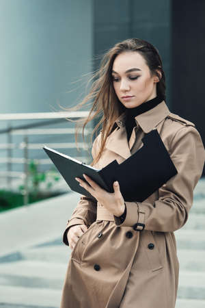 Self-confidence young business woman with file in a hand. outdoor. cityscapeの写真素材