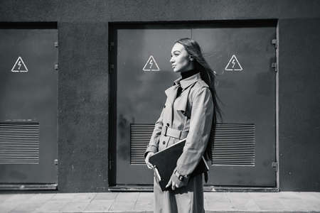 Self-confidence young business woman with file in a hand. outdoor. cityscapeの写真素材