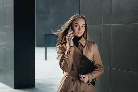 Self-confidence young business woman with file in a hand. outdoor. cityscapeの写真素材