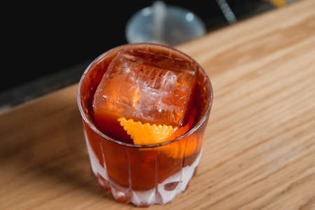 Boulevardie cocktail on a bar desk. Black background