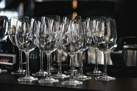Glasses for a margarita, martini, grog and liqueur on a bar at restaurant, against the bar bar wall background.の写真素材