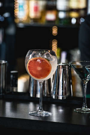 refreshing ruby red coctail with grape fruit isolated on a bar backgroundの写真素材