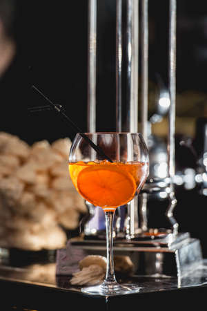 glass of refreshing orange alcoholic cocktail on a table in the bar.の写真素材