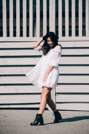 lifestyle portrait of young stylish hipster woman, wearing trendy white dressの写真素材