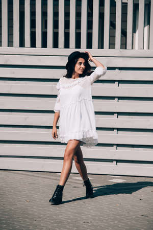lifestyle portrait of young stylish hipster woman, wearing trendy white dressの写真素材