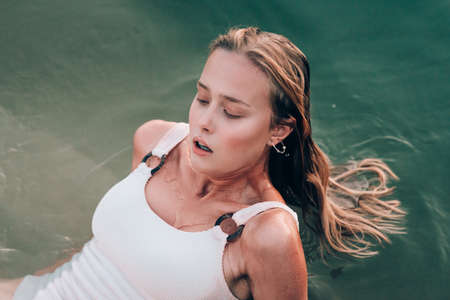 girl in a cold water. Outdoor portrait of pretty curly womanの写真素材