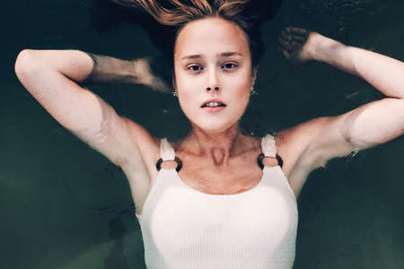 girl in a water. Outdoor portrait of pretty curly womanの写真素材