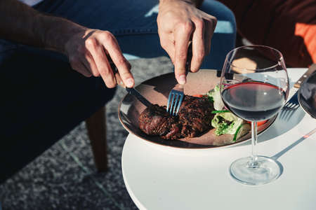 man eating meat with vegetables. Outdoors. Natural lightingの写真素材