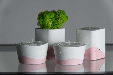 candles and moss in white and pink concrete candle holders.の写真素材