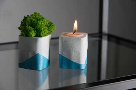 candle and moss in white and blue concrete candle holders.の写真素材