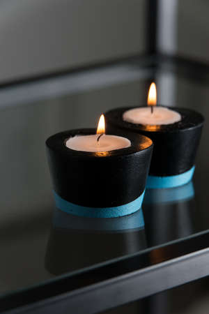 Candles in black and blue concrete candle holders.の写真素材