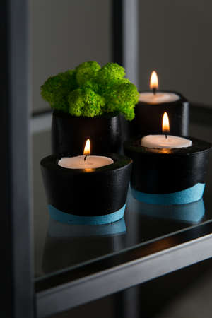 Candles and moss in black and blue concrete candle holders.の写真素材