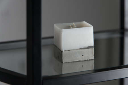 white candle on a concrete base.の写真素材