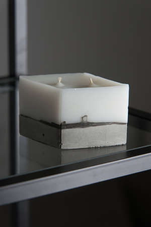 white candle on a concrete base.の写真素材