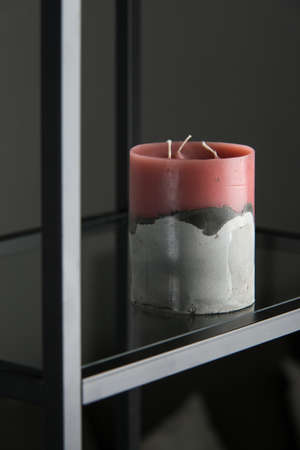 red candle on a gray concrete base.の写真素材