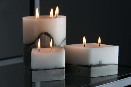 white candle on a concrete base.の写真素材