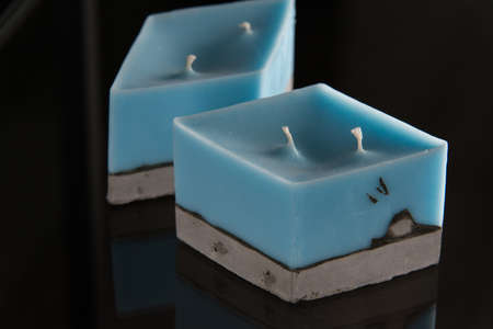 blue candle on a gray concrete base.の写真素材