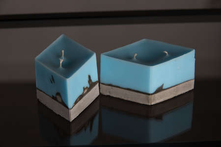 blue candle on a gray concrete base.の写真素材