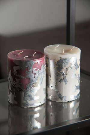 red and white candle on a gray concrete base.の写真素材