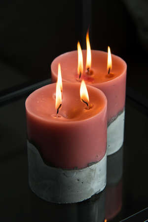 red candle on a gray concrete base.の写真素材