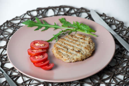 juicy fried meat cutlet with tomato on a plate.の写真素材