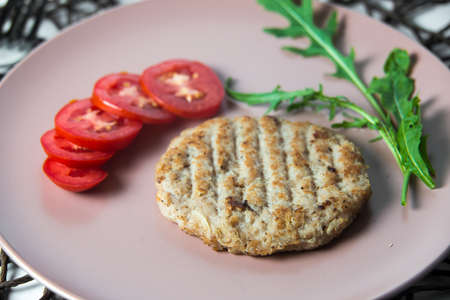 juicy fried meat cutlet with tomato on a plate.の写真素材