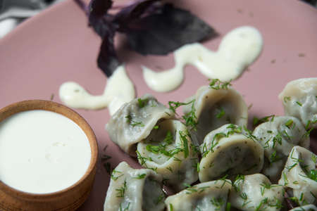 meat dumplings, homemade traditional Ukrainian dish pelmeni with sour creamの写真素材