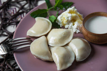dumplings with cheese, homemade traditional Ukrainian dish varenyky with sour creamの写真素材