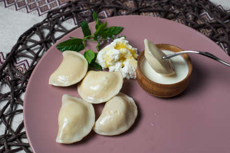 dumplings with cheese, homemade traditional Ukrainian dish varenyky with sour creamの写真素材