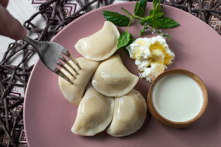 dumplings with cheese, homemade traditional Ukrainian dish varenyky with sour creamの写真素材