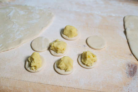 Woman making ukrainian dumplings with potatoes and cottage cheese.の写真素材