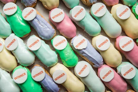 sweet and colorful eclair on glass. french eclair with word winner on top. hight angle view.の写真素材