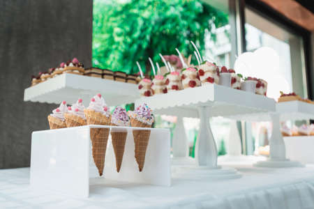 Waffle cones with ice cream on table.