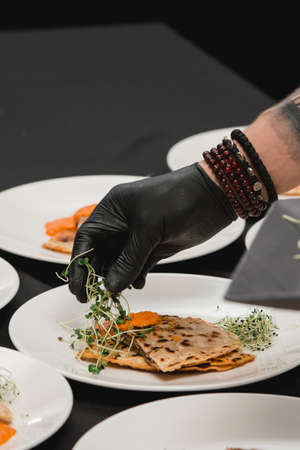 Uzbek eastern Tatar cuisine, cheburek with meat on a white plate with microgreen and sauceの写真素材