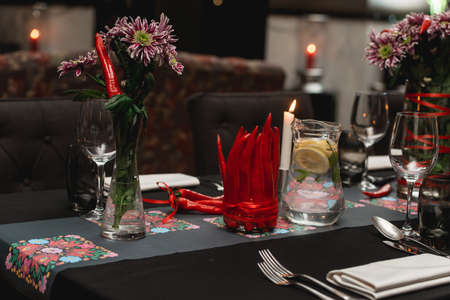 Served restaurant table. Red pepper decoration on a black tablecloth.の写真素材
