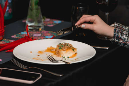 Woman eating stewed rabbit on a piece of homemade bread.