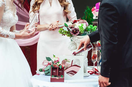 bride and groom pour colored sand in the bottle. Wedding ceremony. Decorative box for rings