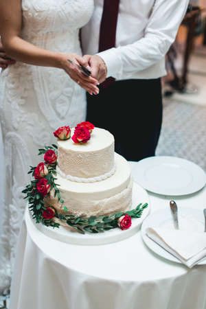 wedding ceremony. the bride and groom make their first case together, cut the white wedding cakeの写真素材