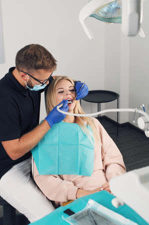 Portrait of a dentist who treats teeth of young woman patient.の写真素材