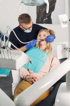 Portrait of a dentist who treats teeth of young woman patient.の写真素材