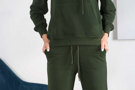 Stylish beautiful young blond woman in a biege tracksuit poses near a white wall in the room. Fitness ladyの写真素材