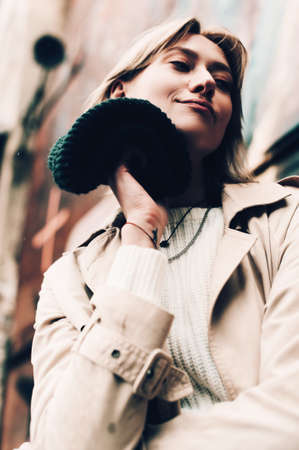 Beautiful woman sitting alone in cafeteria, smoking a cigarette and drinking coffee. Autumn moodの写真素材